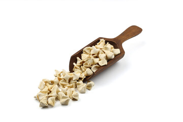 handmade manti (turkish ravioli type dumplings) on wooden scoop,  before cooking. isolated on white background