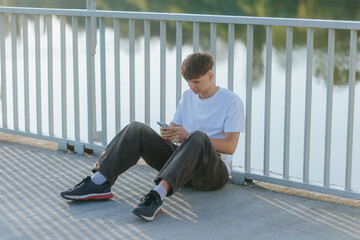Teenager Deep in Thought, Using Smartphone Alone in the Park