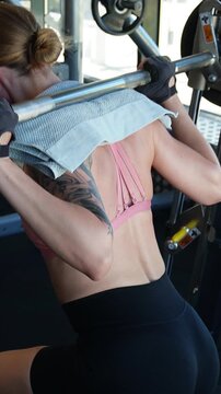 Female Athlete Doing Lunges on Smith Machine, vertical video.
Woman performing lunges on a Smith machine in the gym. Strength workout, fitness training, bodybuilding exercise. 9:16