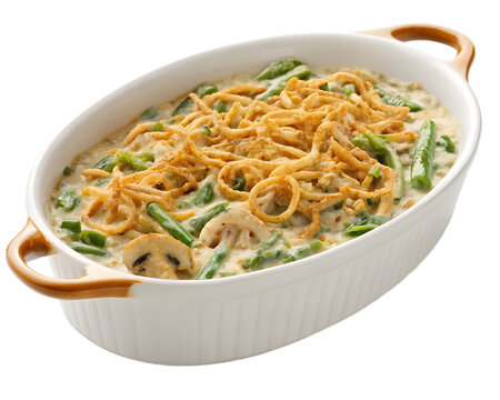 A casserole dish filled with green bean casserole topped with crispy fried onion strings on top view