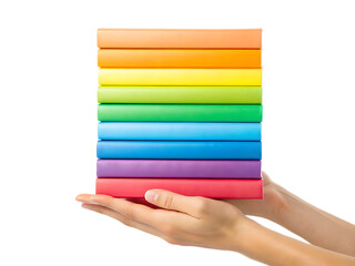 Hands holding a stack of colorful books arranged in a rainbow gradient on a white background plane