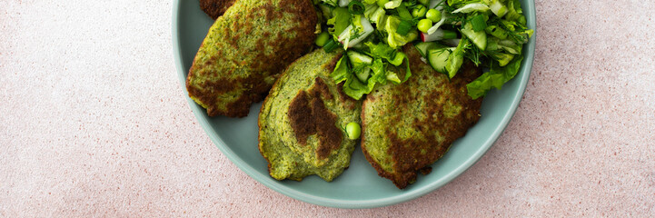 Enjoy zucchini and broccoli pancakes paired with a fresh mixed salad featuring cucumbers, young...