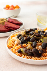 Gluten-free pasta with baked beans and zucchini, paired with beet pancakes topped with sunflower...