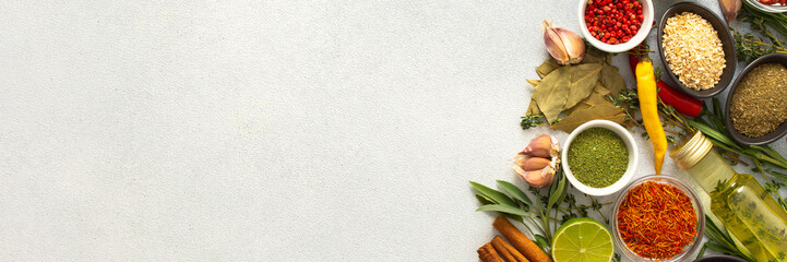 A wide selection of cooking spices and herbs on a gray background, perfect for adding depth to any...