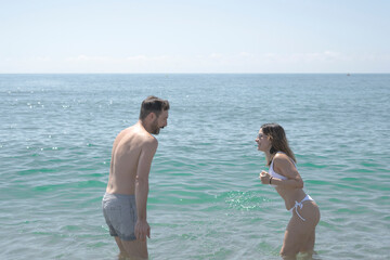 Happy couple enjoying summer vacation, playing in the sea