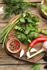 Different fresh herbs and spices on wooden table, flat lay