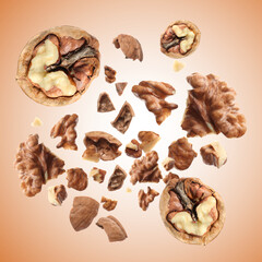 Walnuts swirling in air against pale brown background