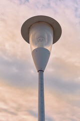 Vintage-style street lamp framed by a pastel sunset sky, highlighting warm tones and cinematic urban atmosphere.