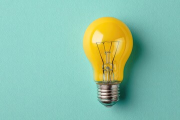 A single, bright yellow lightbulb against a pale teal background