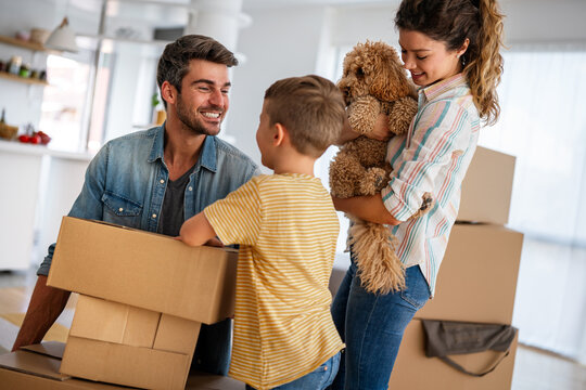Happy family with child moving with boxes in a new apartment house. Mortgage, real estate investment
