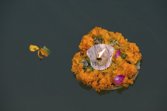 Leaf bowl with flowers and oil lamp floating on the Ganges river, Varanasi, Uttar Pradesh, India, Asia