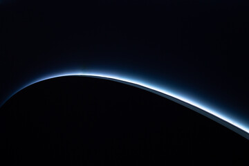 Abstract background with a glowing blue curve on dark surface. Minimal futuristic gradient design...
