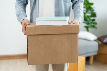 Naklejka na ściany i meble People relocation move home concept, Man carrying belongings box moving in new apartment.