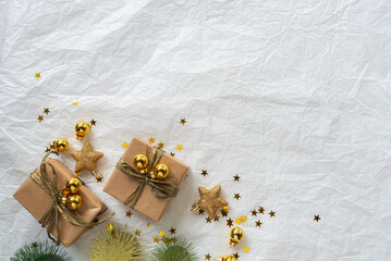 Gold Christmas theme decorations on paper texture background,  Christmas tree, gold presents box, decorative gold stars and Christmas ball. 