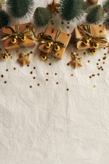 Gold Christmas theme decorations on paper texture background,  Christmas tree, gold presents box, decorative gold stars and Christmas ball. 