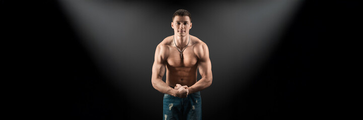Fototapeta premium Muscular Man in Spotlight on Wide Banner