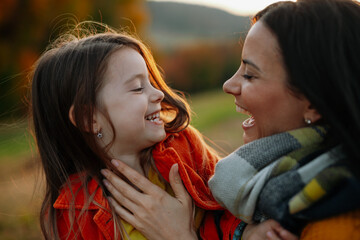 Young mother with a small daughter in autumn nature.