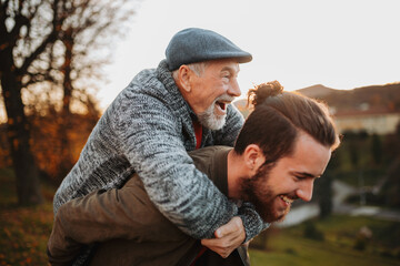 Senior father and his son walking in nature, having fun.