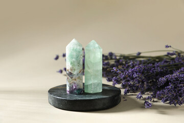 Aura. Different crystals and lavender flowers on beige background, closeup
