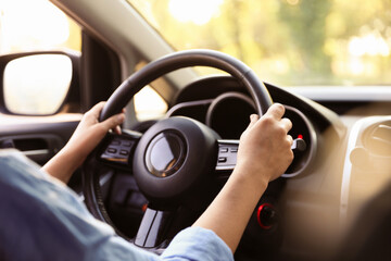 Woman behind steering wheel of modern car, closeup