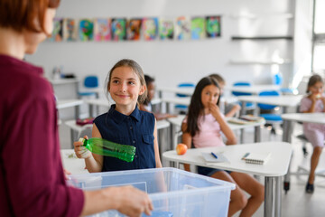Young children learning about sustainability and ecology, sorting waste.