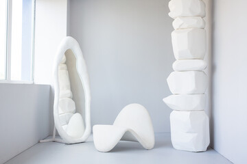 Armchair, mirror and improvised column on white background with window