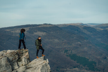 Fototapeta premium Hikers standing on mountain peak enjoying scenic view