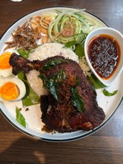 Traditional Nasi Lemak with Fried Chicken, Sambal, Egg, and Sides
