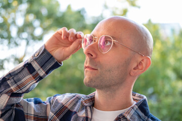 Thoughtful young Bald man looking up contemplating in soft natural light, Portrait adult male,...