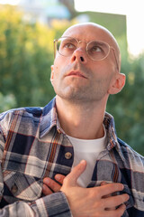 Bald man clutching chest in pain, sudden cardiac symptom, heart discomfort, possible rare cardiac...