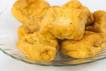 Close up Golden fried tofu squares on a glass plate enticing street food snack or vegan protein...