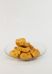 Crispy fried tofu cubes served on elegant glass plate, ready for delicious vegan meals and healthy recipes