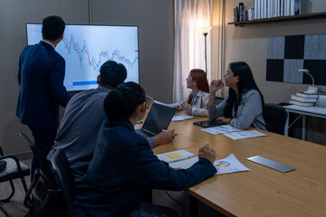 Team collaborates during a business meeting analyzing market trends and data in a modern office