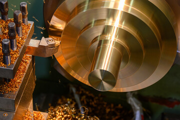 Close up scene the lathe machine finish cut the brass material parts by chip insert tool.