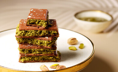 Dubai chocolate. Chocolate bars stacked elegantly on a plate, showcasing rich textures and vibrant...