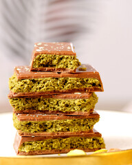 Dubai chocolate. Chocolate bars stacked elegantly on a plate, showcasing a rich texture and vibrant...