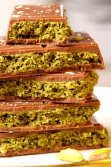 Dubai Chocolate bars stacked with a unique green filling, showcasing a rich texture and vibrant...