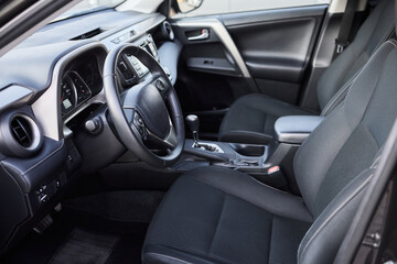 Closeup of a modern car steering wheel with control buttons for technology and convenience