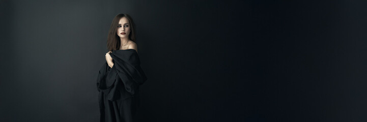 Fototapeta premium Woman in Black Attire with Dramatic Look Wide Banner