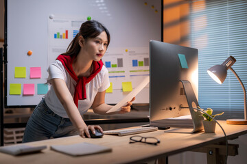 A woman is standing in front of a computer monitor with a red shirt on