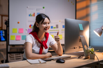 A woman is sitting at a desk with a computer monitor and a keyboard