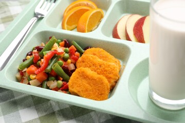 Plastic tray with tasty food, milk and fork on table, closeup. School lunch