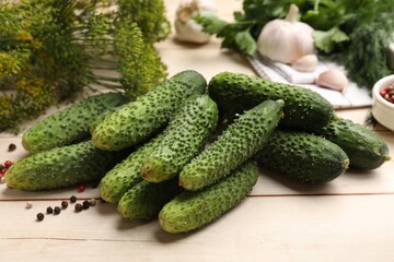 Making pickles. Fresh cucumbers, peppercorns and dill on light wooden table, closeup