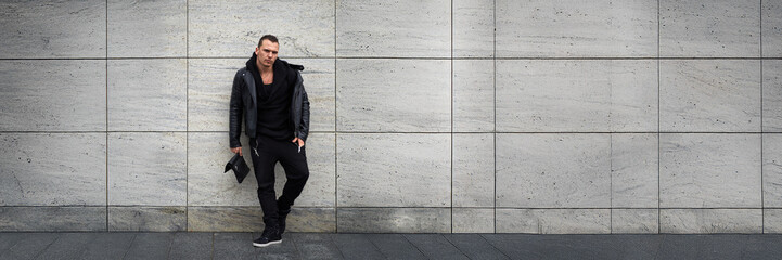 Man in Black Outfit Leaning on Wall Wide Banner