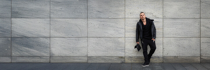 Stylish Man in Black Outfit on Grey Wall Wide Banner