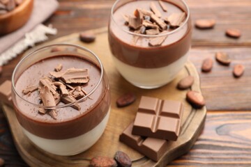 Delicious panna cotta with chocolate and cocoa beans on wooden table, closeup