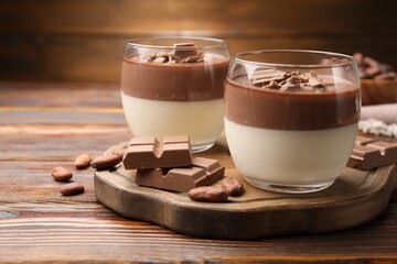 Delicious panna cotta with chocolate and cocoa beans on wooden table, closeup