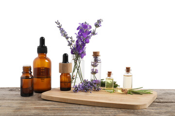 Bottles of essential oils and different plants on wooden table against white background