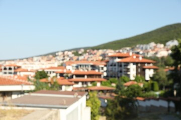 Blurred view of buildings and green mountain