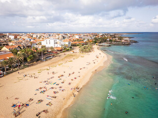 Aerial drone shot of the Santa Maria pier and beach, Sal Island, Cape Verde, at golden sunset. Turquoise waters, fishing boats and a tropical atmosphere in high resolution.